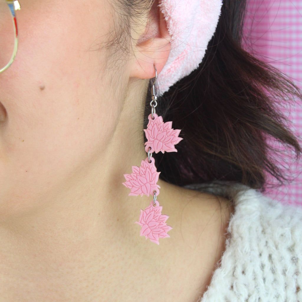 Model wearing Pink acrylic cascading lotus flower charms on stainless steel earwires.