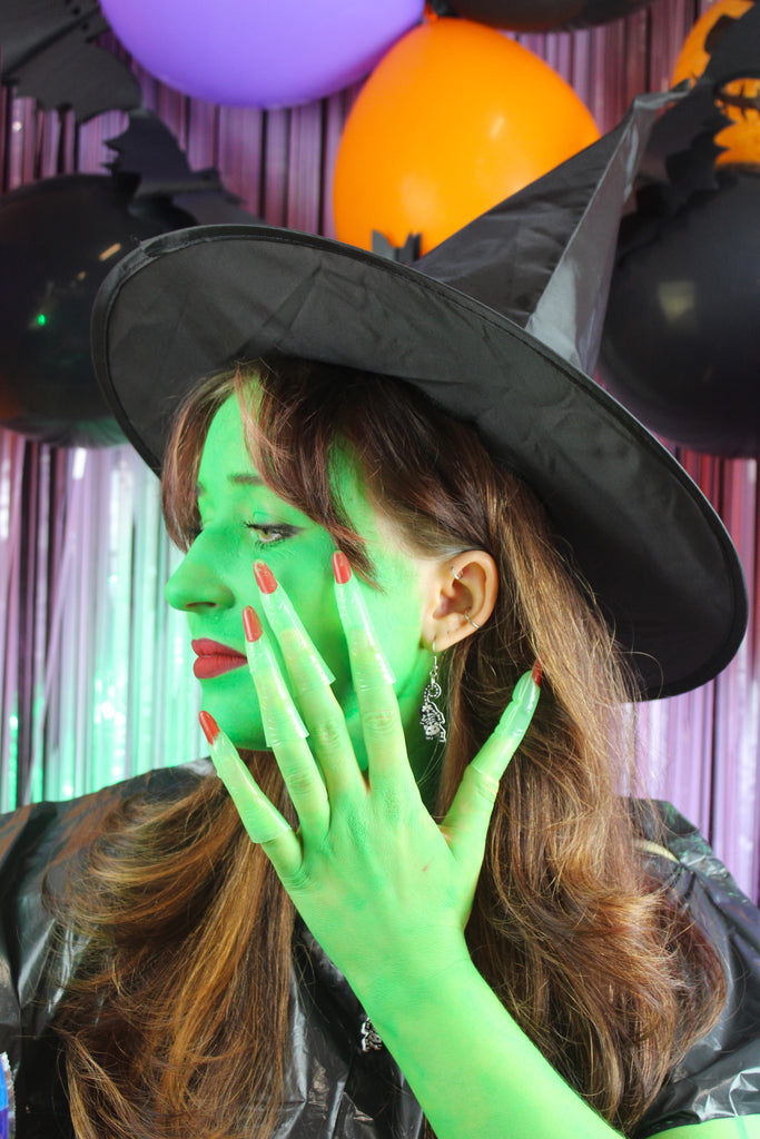 Model wearing cat skeleton charms on stainless steel earwires 