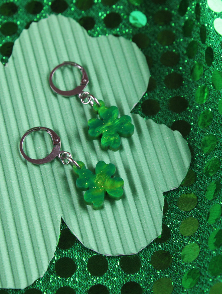 Glittery four leaf clover charms on stainless steel huggie hoops