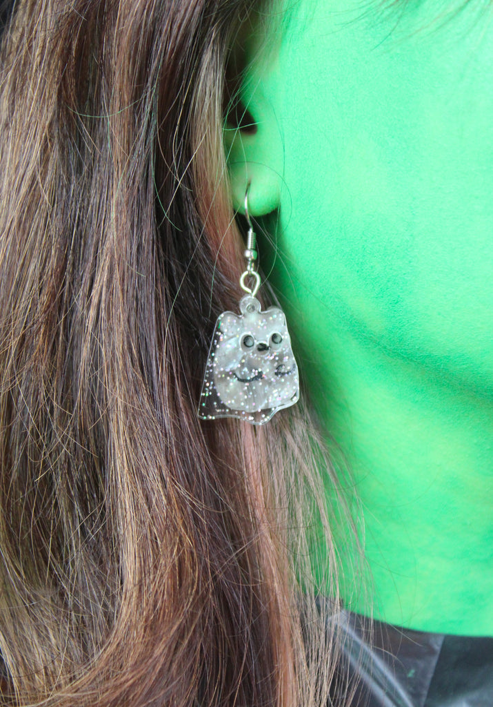 Ear wearing Grey hamster charms with an additional layer of holographic glitter to replicate a ghost on stainless steel earwires