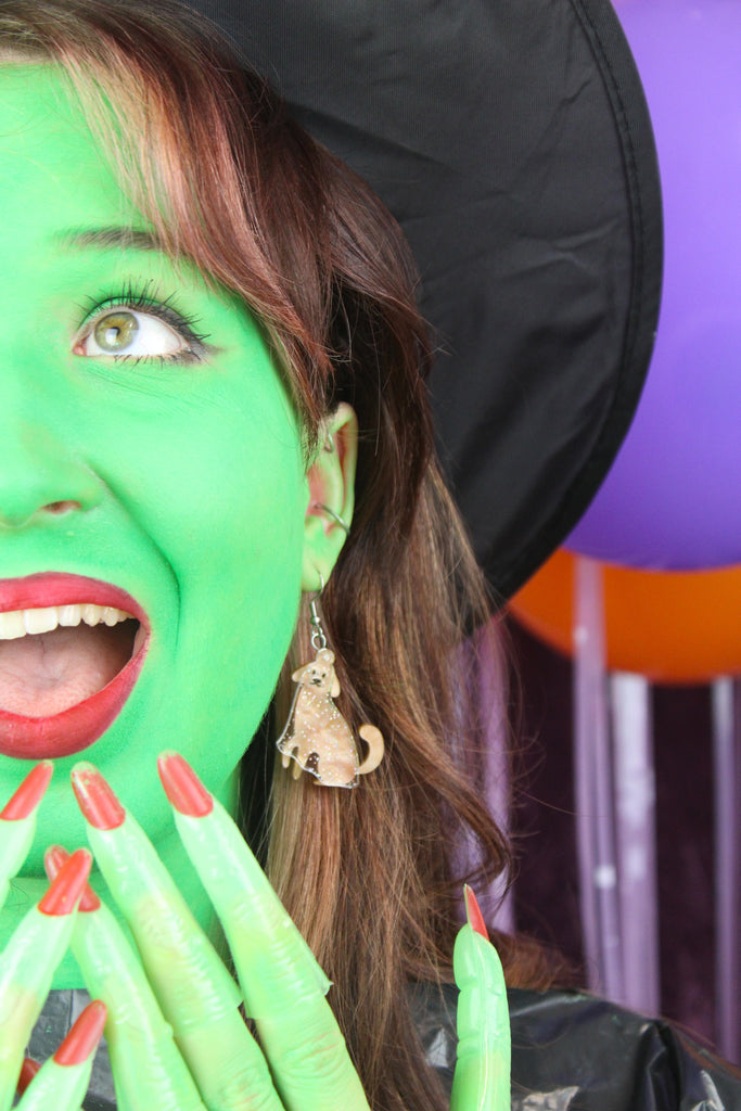 model wearing Dog charms with an extra layer of holographic glitter to replicate a ghost n stainless steel earwires