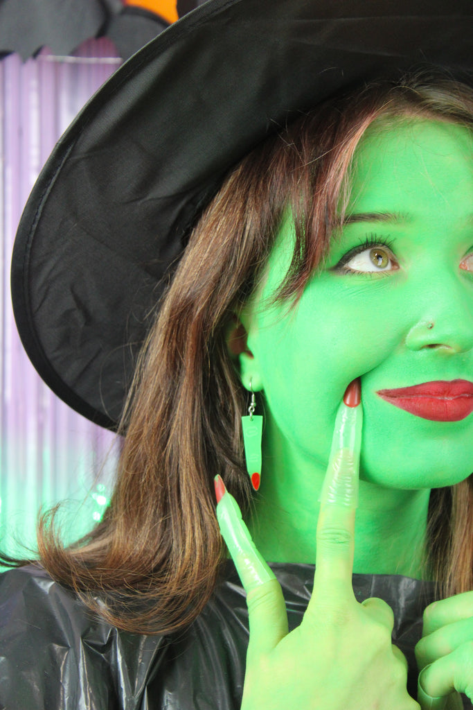 Model wearing Green witch's finger charm on stainless steel earwires