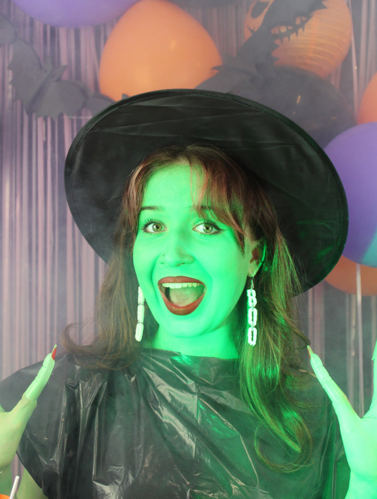 MODEL WEARING THE LETTERS B, O, O SPELLED OUT VERTICALLY WITH A WHITE DRIPPY EFFECT ON STAINLESS STEEL EARWIRES