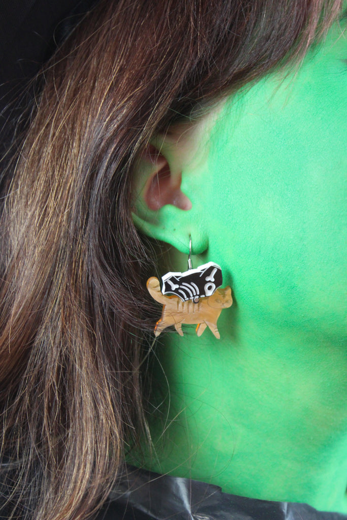 ear wearing ginger cat skeleton charms on stainless steel earwires 