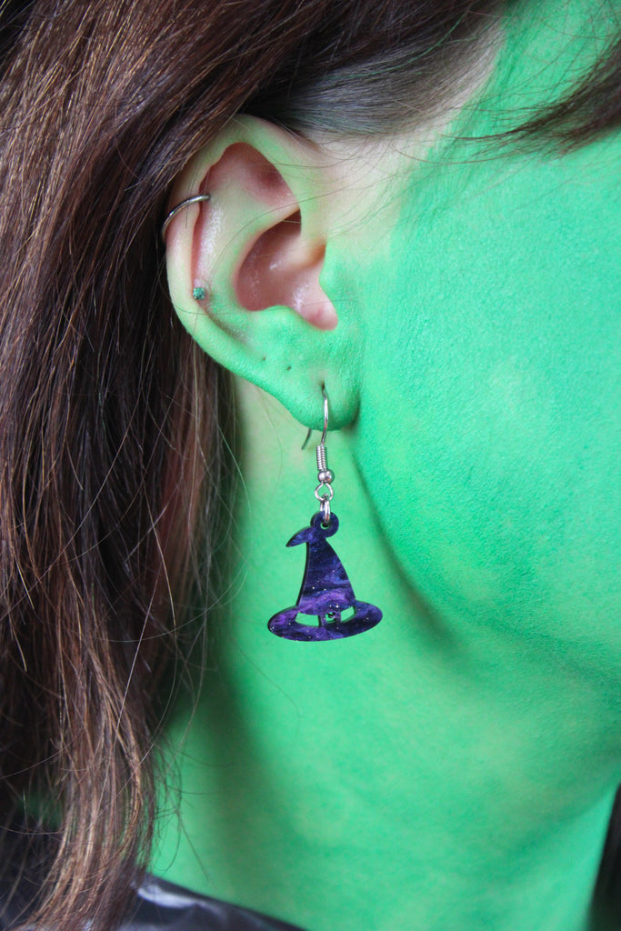 Model wearing Galaxy inspired glittery witch's hat charms on stainless steel earwires