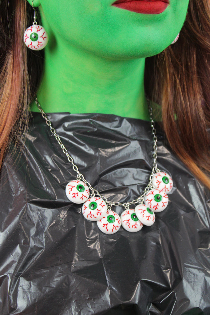 Model wearing Seven Bloodshot eye pendants on an oval link stainless steel chain, with matching earrings.
