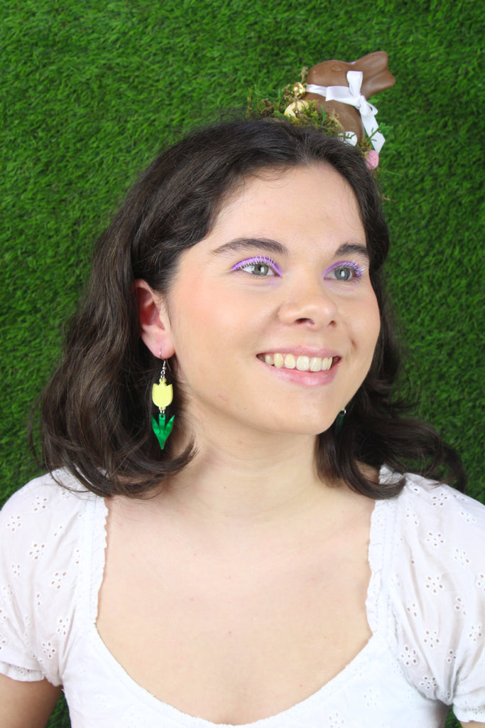 Model wearing Yellow acrylic tulip charms with green stems on stainless steel earwires