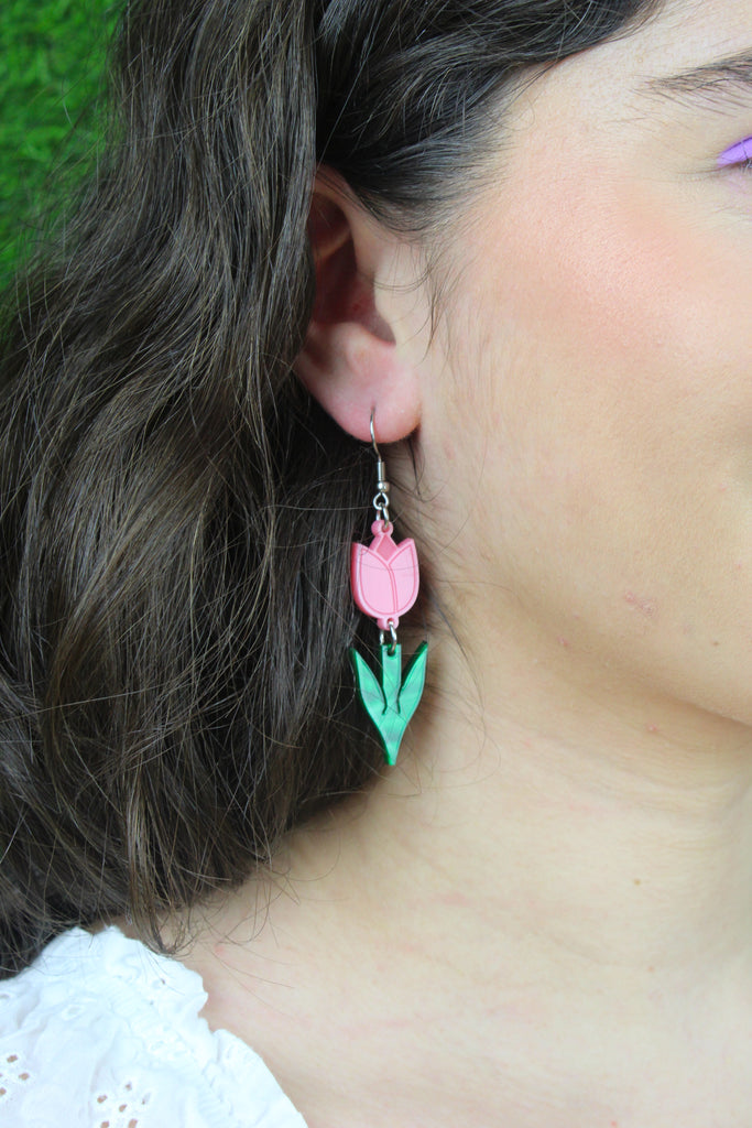 Model wearing Pink acylic tulip charms with green stems on stainless steel earwires