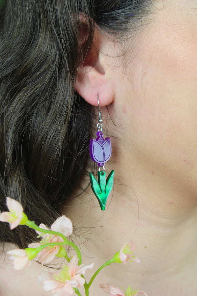 Model wearing Purple acrylic tulip charms with green stems on stainless steel earwires