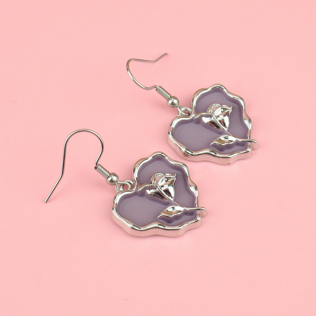 a base metal charm with a beautiful rose in the centre of a purple heart, suspended from sleek stainless steel ear wires