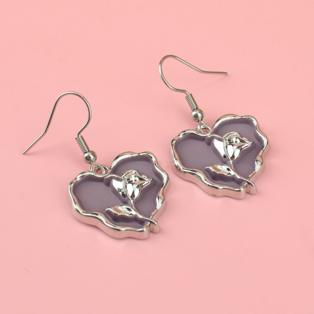 a base metal charm with a beautiful rose in the centre of a purple heart, suspended from sleek stainless steel ear wires