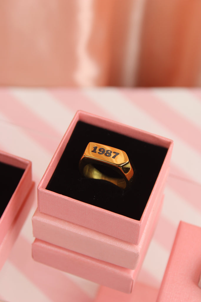 Chunky gold plated stainless steel ring with birth year engraved in black in a gift box