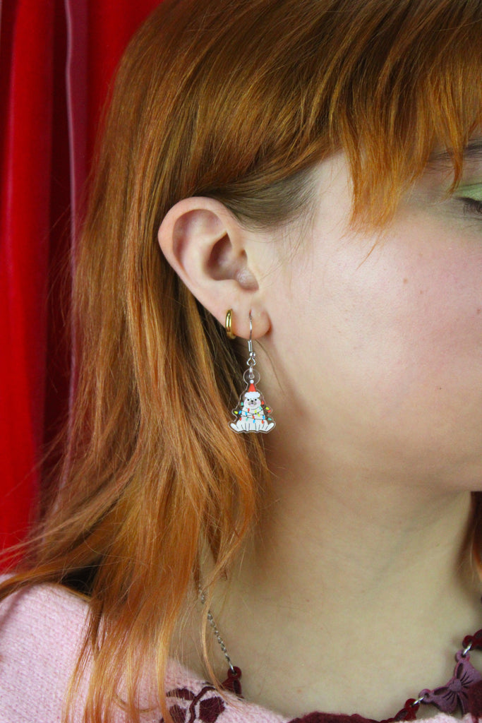 Close-up of a person wearing a pug earring with a red curtain background