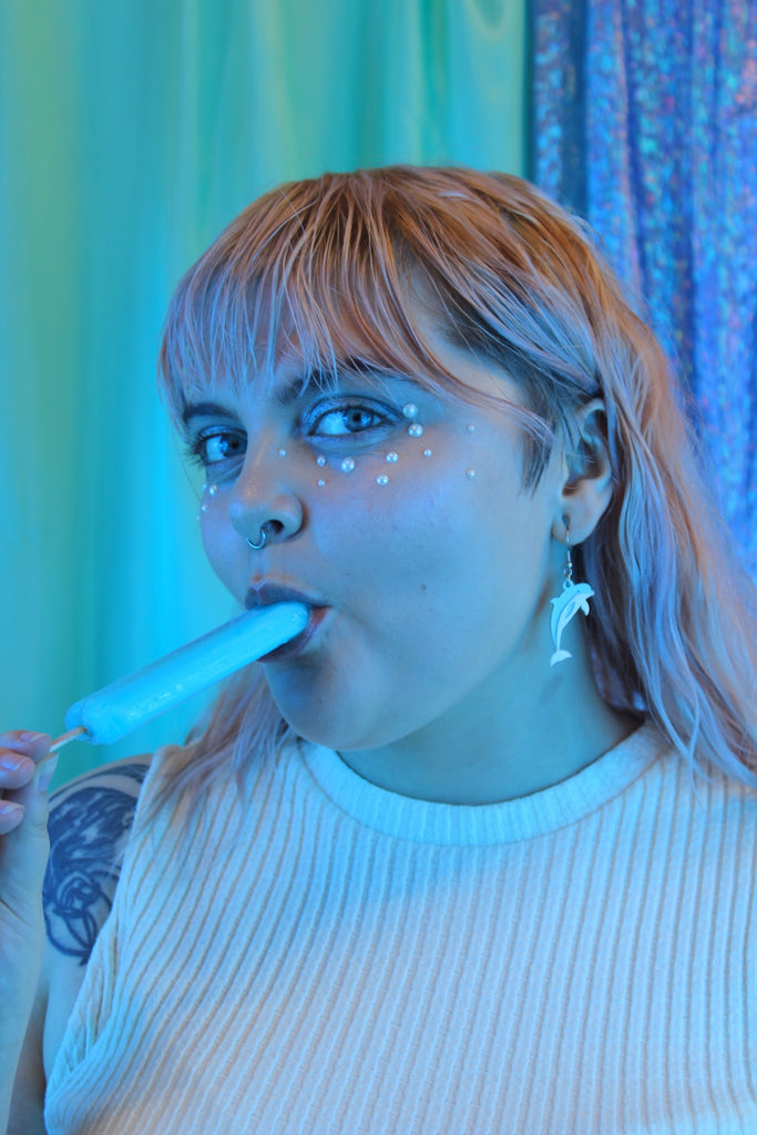 Model wearing Light blue acrylic Dolphin charms on stainless steel earwires