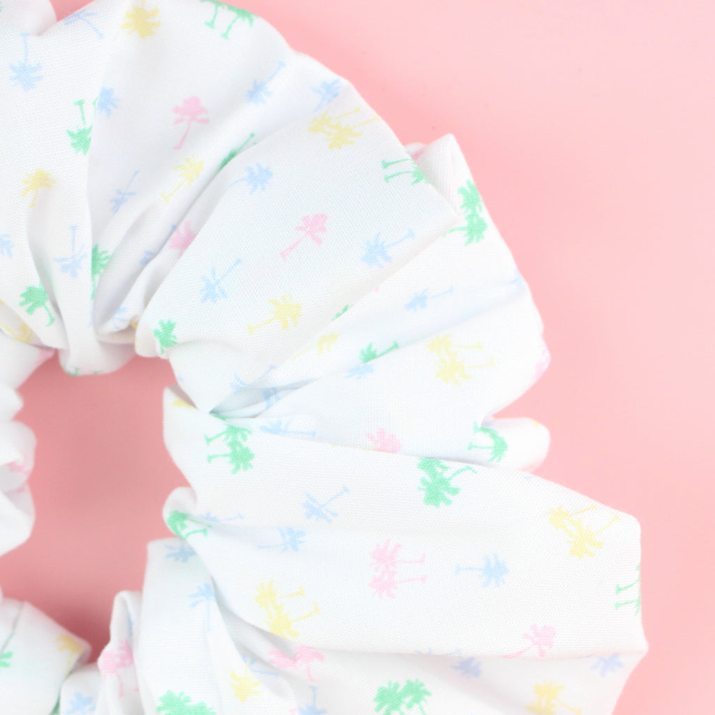 White scrunchie with green, yellow, blue and pink palm trees palm tree print