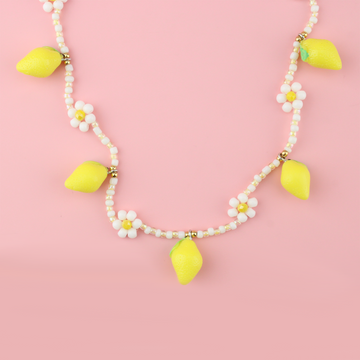 Resin lemon charms on a necklace with glass beads forming a daisy design and a gold plated stainless steel clasp