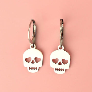 Stainless steel skull charms with cut out heart eyes on stainless steel hoops