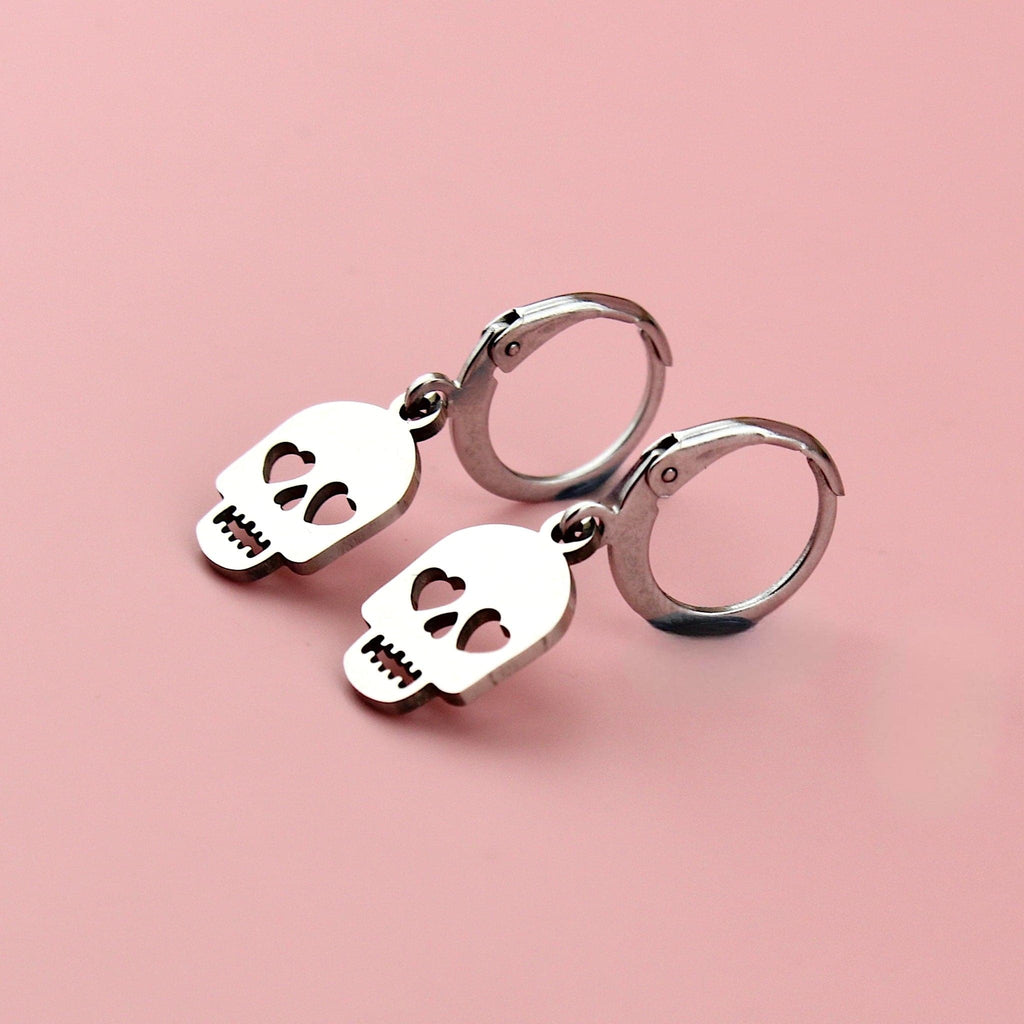 Stainless steel skull charms with cut out heart eyes on stainless steel hoops