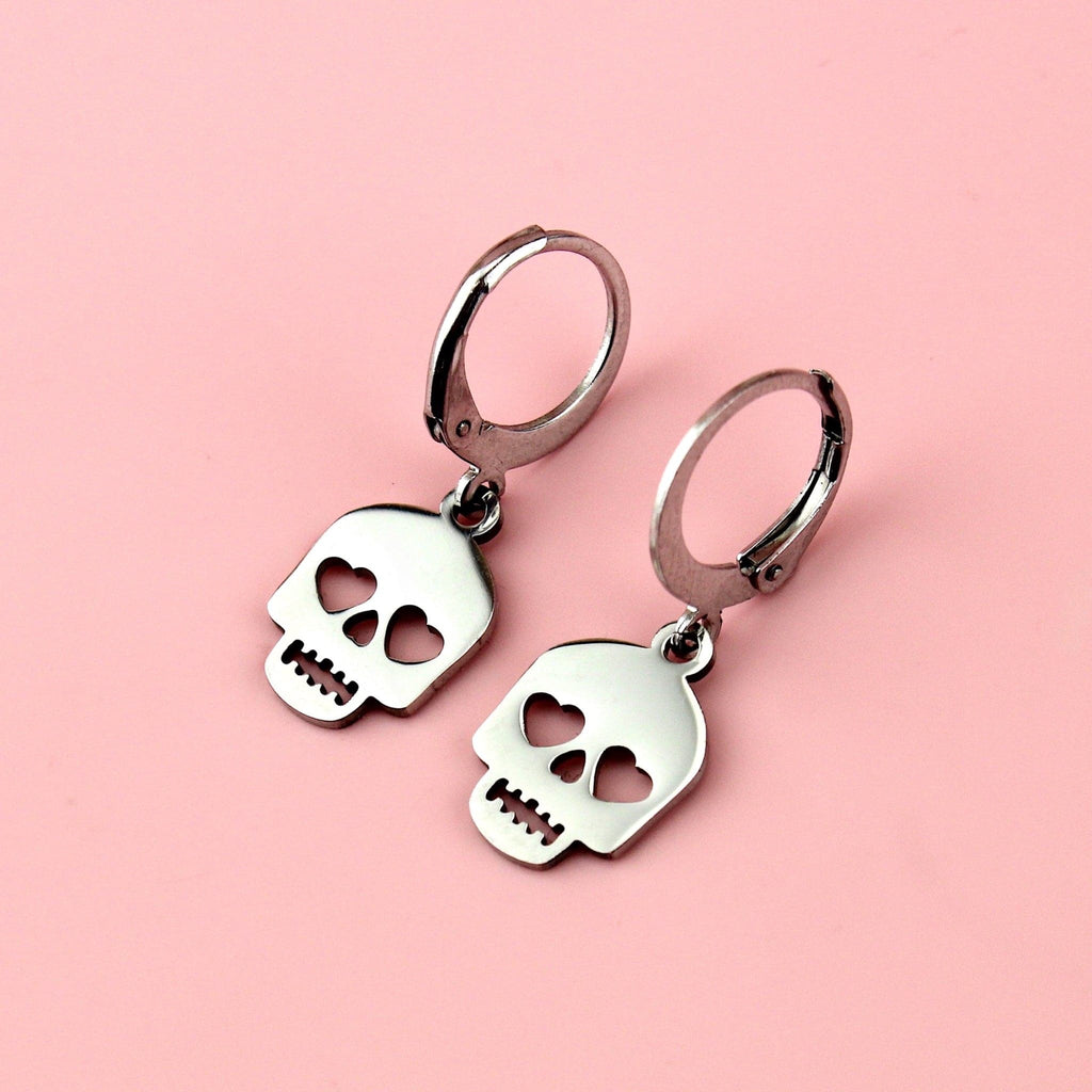 Stainless steel skull charms with cut out heart eyes on stainless steel hoops