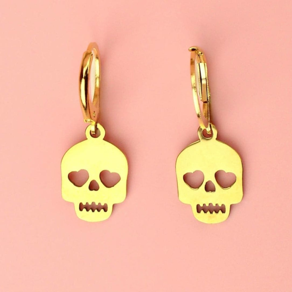 Gold plated skull charms with cut out heart eyes on gold plated stainless steel hoops