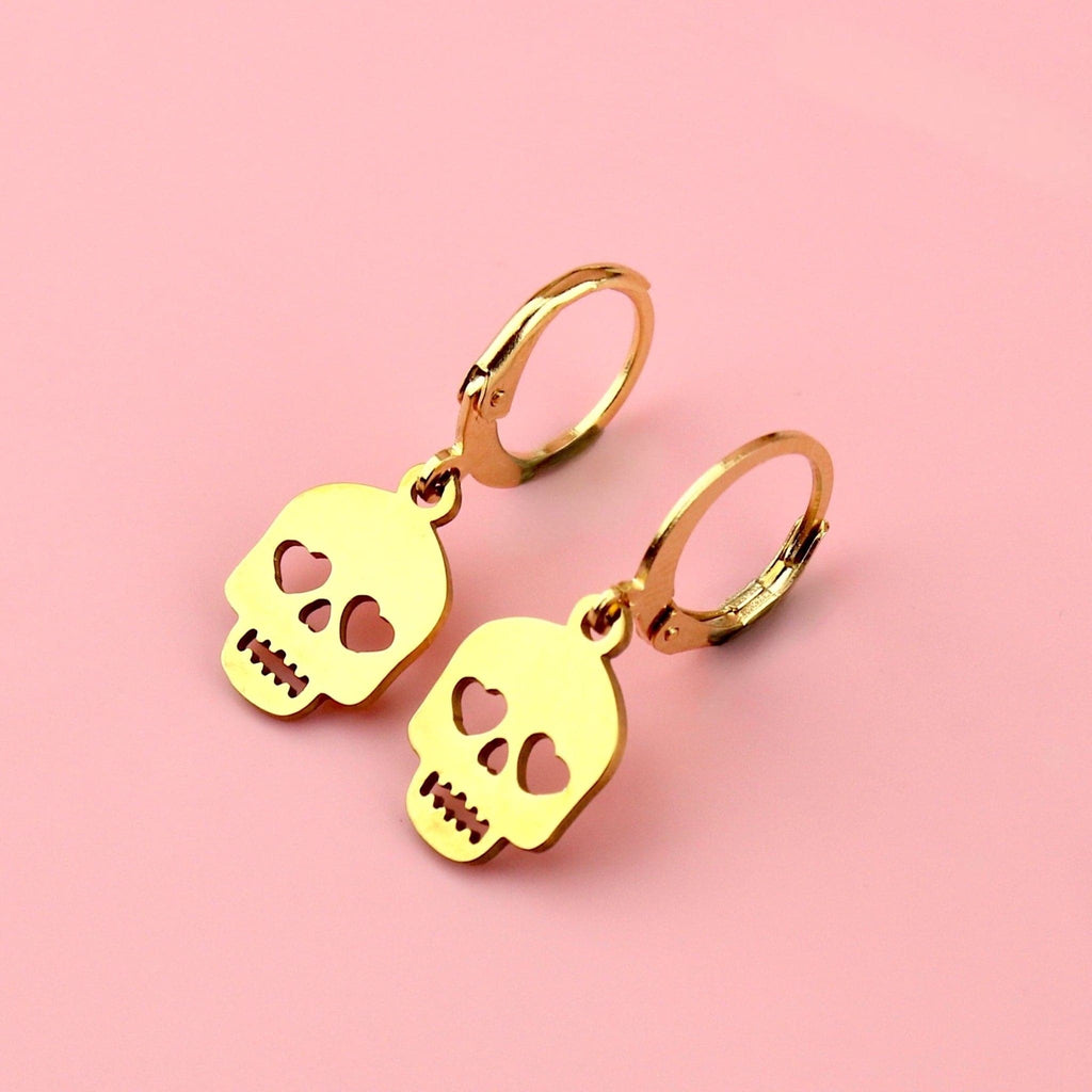 Gold plated skull charms with cut out heart eyes on gold plated stainless steel hoops