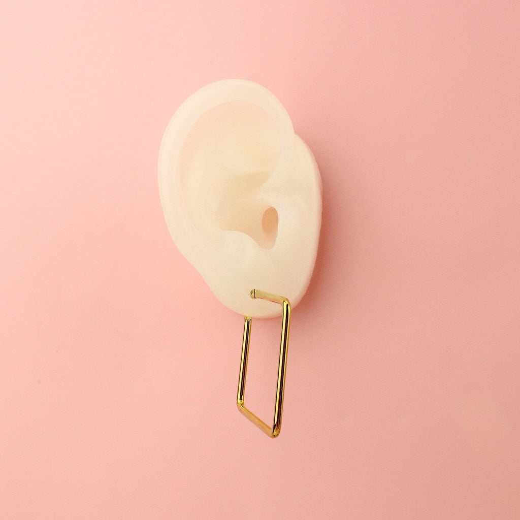 Ear wearing Gold square-shaped hoops