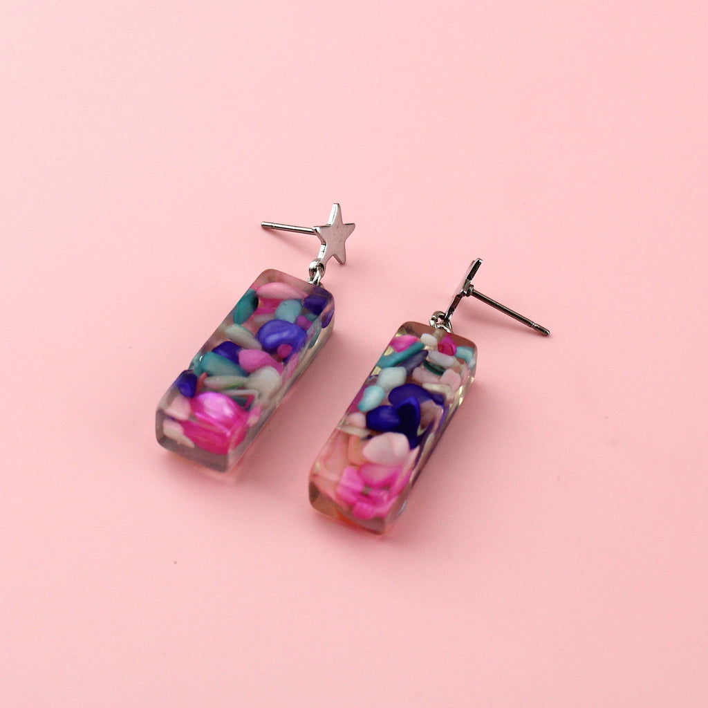 A resin shell with blue, purple and pink stones inside on star shaped studs