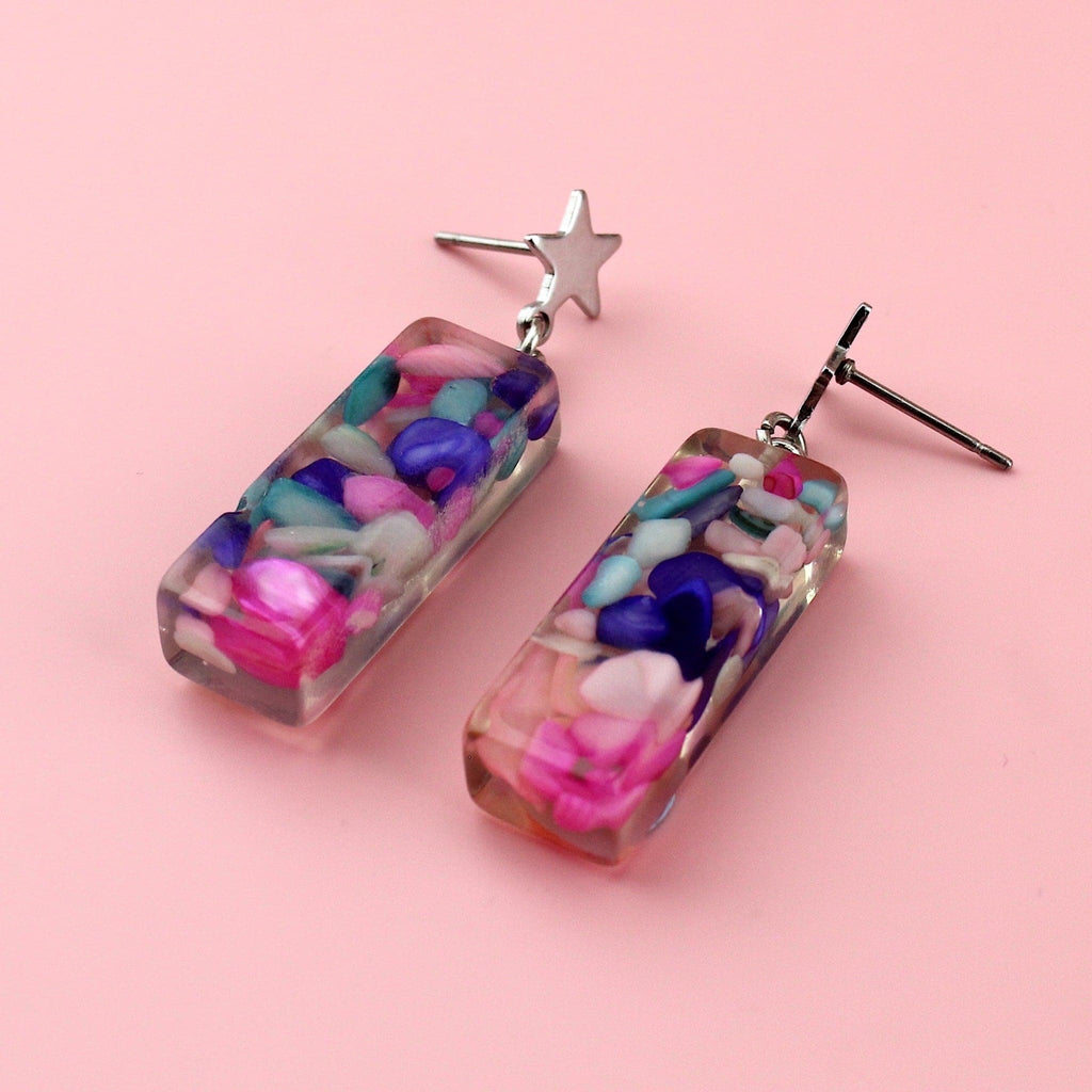 A resin shell with blue, purple and pink stones inside on star shaped studs