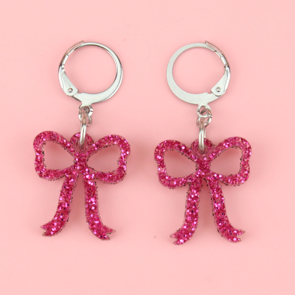 Mini pink glitter bow charms on stainless steel huggie hoops
