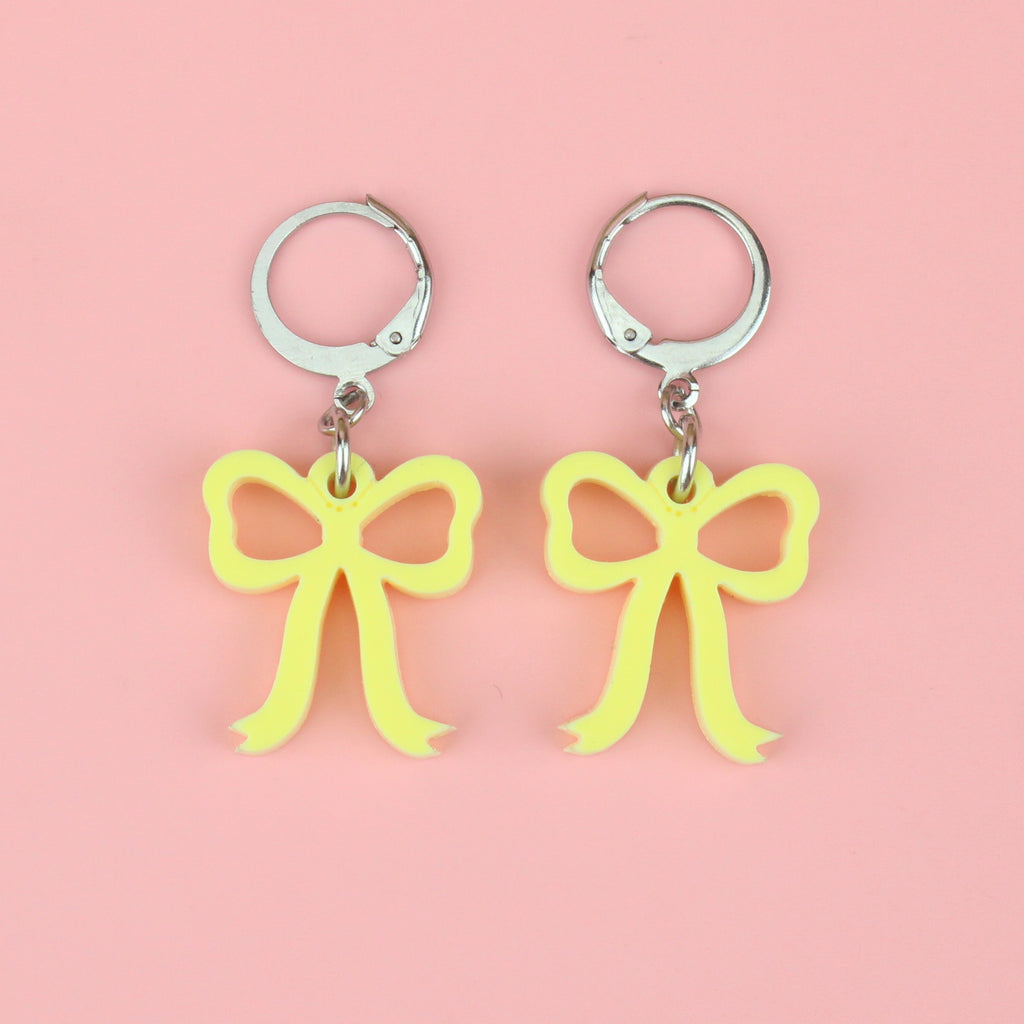 Baby yellow bow charms on stainless steel huggie hoops
