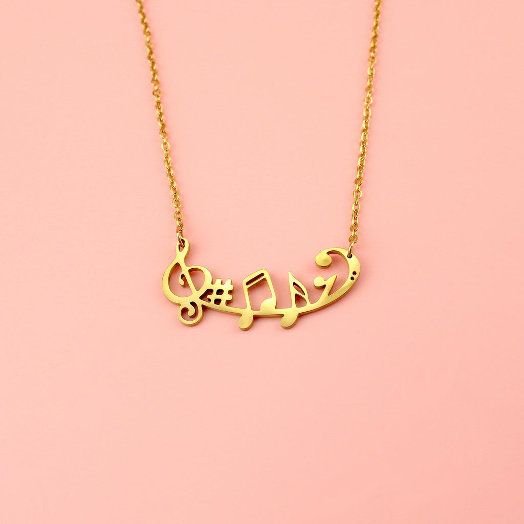 Gold plated stainless steel necklace with music notes including a treble clef, sharp and a semiquaver