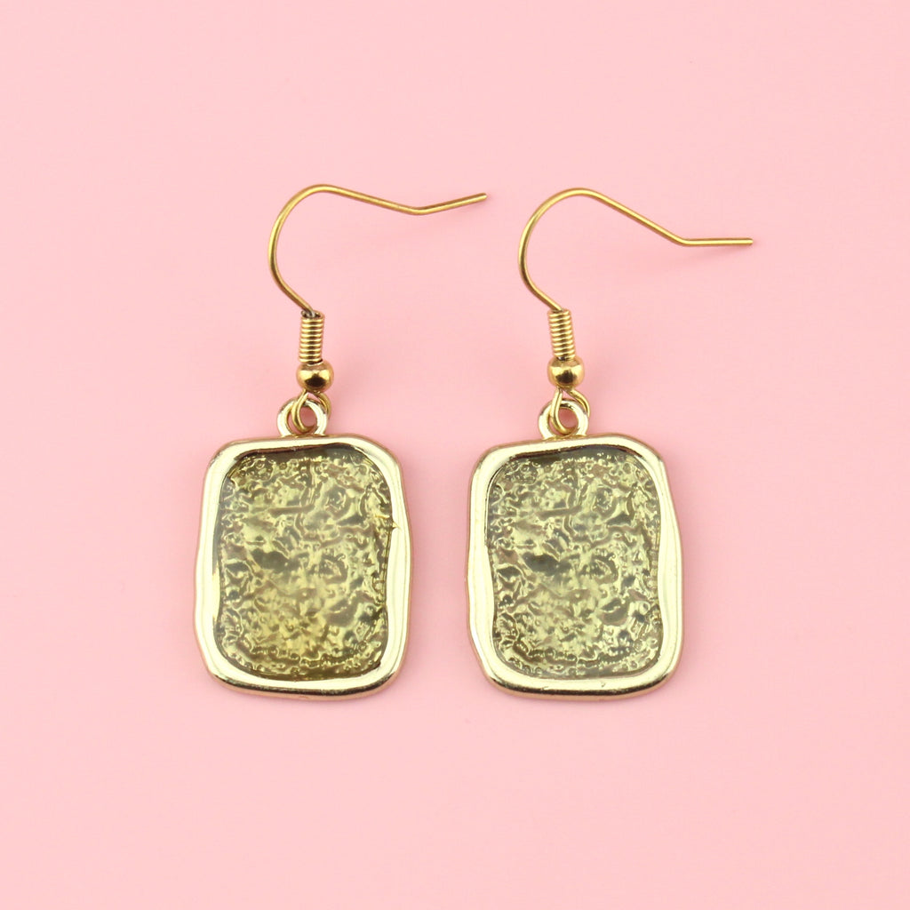 Gold rectangular shaped earrings with a wavy outline and a shimmery olive coloured centre