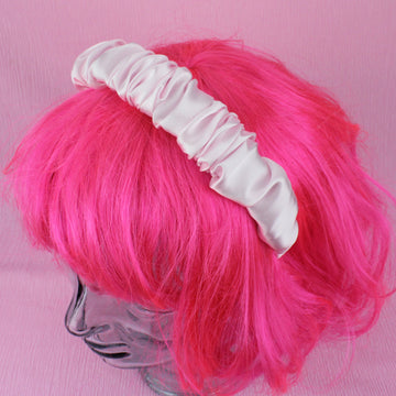 Pink satin scrunchie style headband shown on a wig for scale