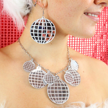 Model wearing Necklace with disco ball pendants varying in size. there are four small disco balls, 2 medium sized disco balls and a large disco ball at the bottom. Model is also wearing the matching earrings