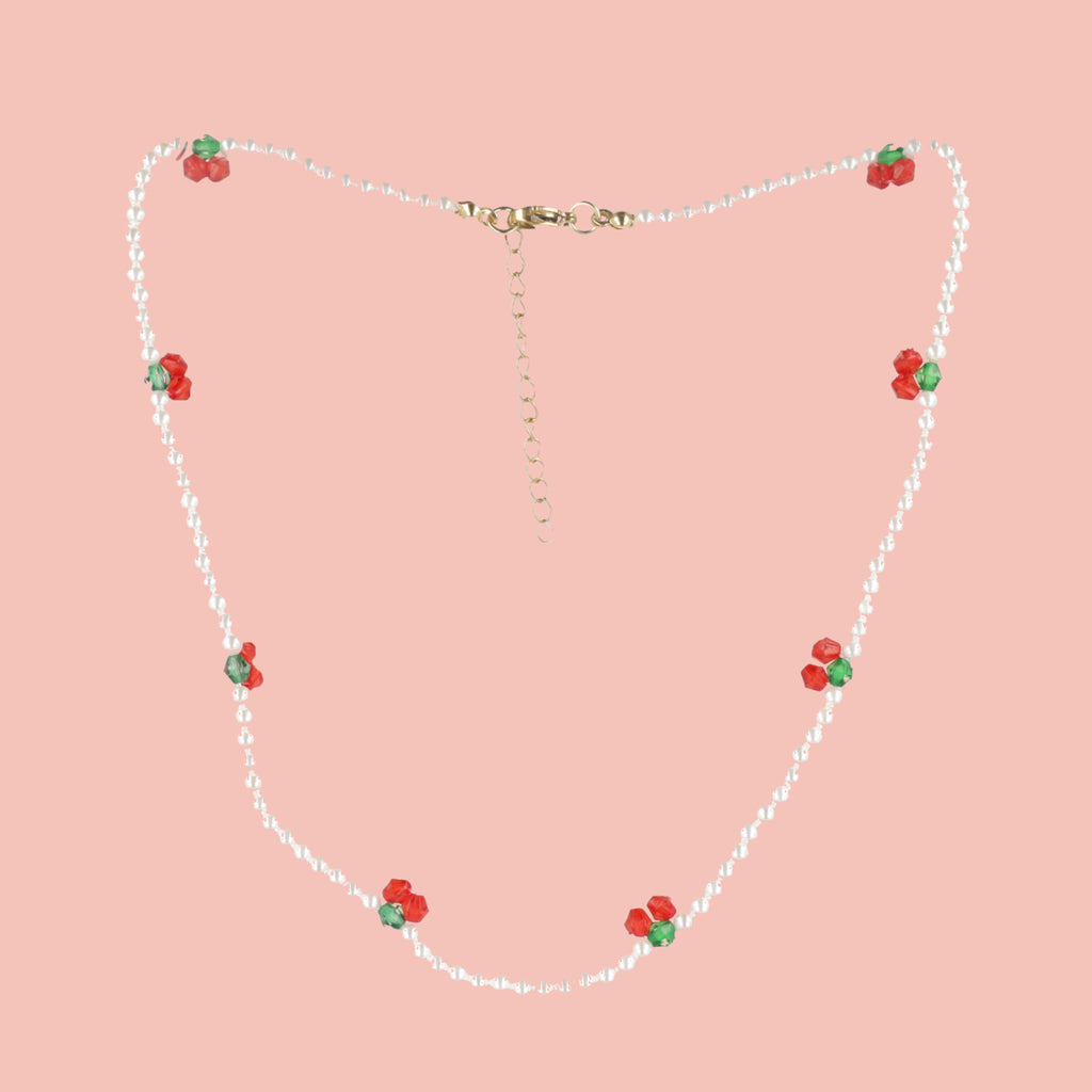 faux pearl beads and cherry charms with a gold plated stainless steel clasp