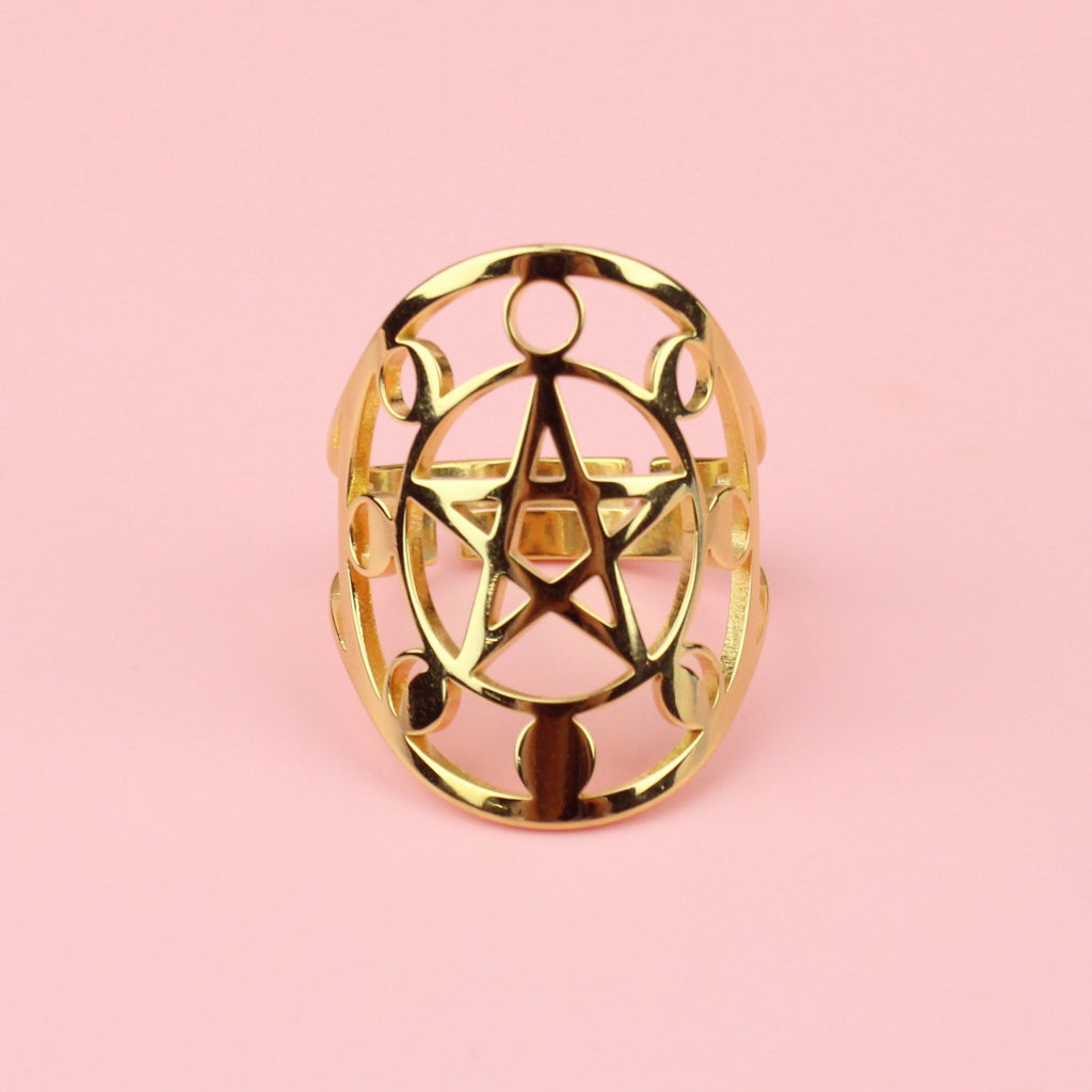 Gold plated stainless steel ring with an oval shaped front featuring a cut out pentacle in th middle and a moon phase design surrounding it