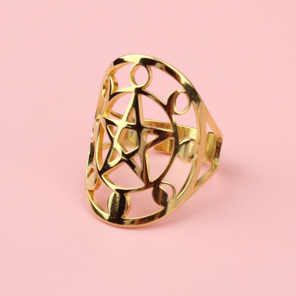 Gold plated stainless steel ring with an oval shaped front featuring a cut out pentacle in th middle and a moon phase design surrounding it