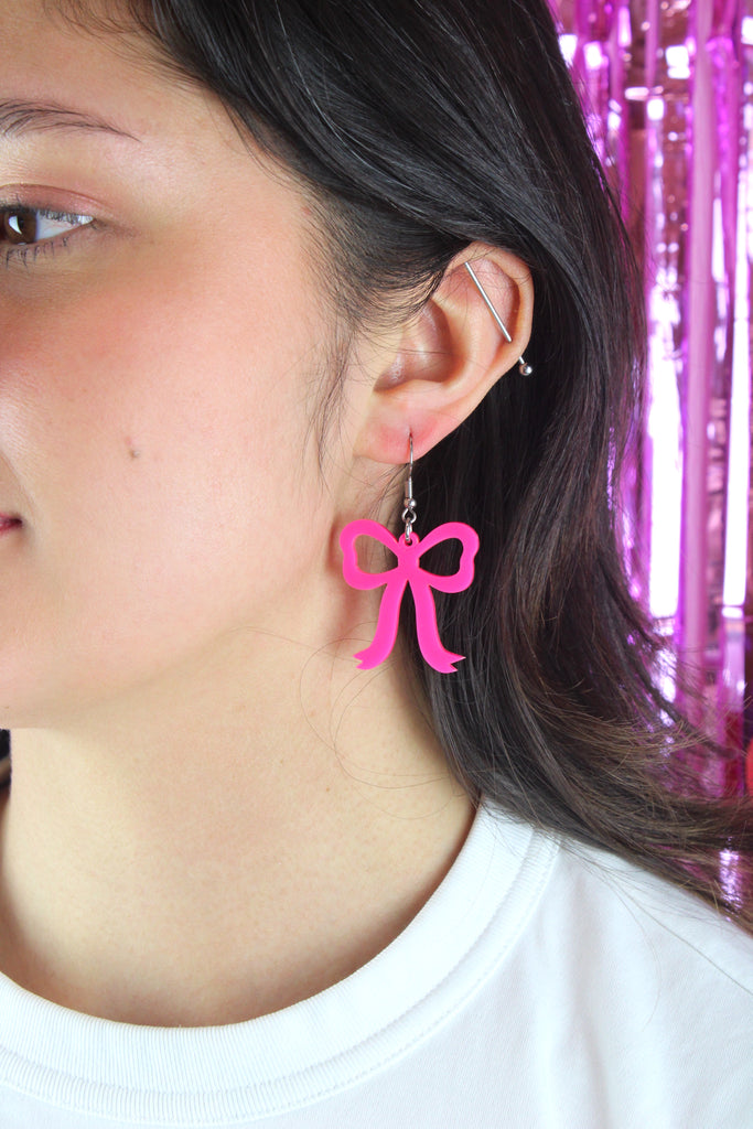 Model wearing Hot Pink Bow Charms on stainless steel earwires 