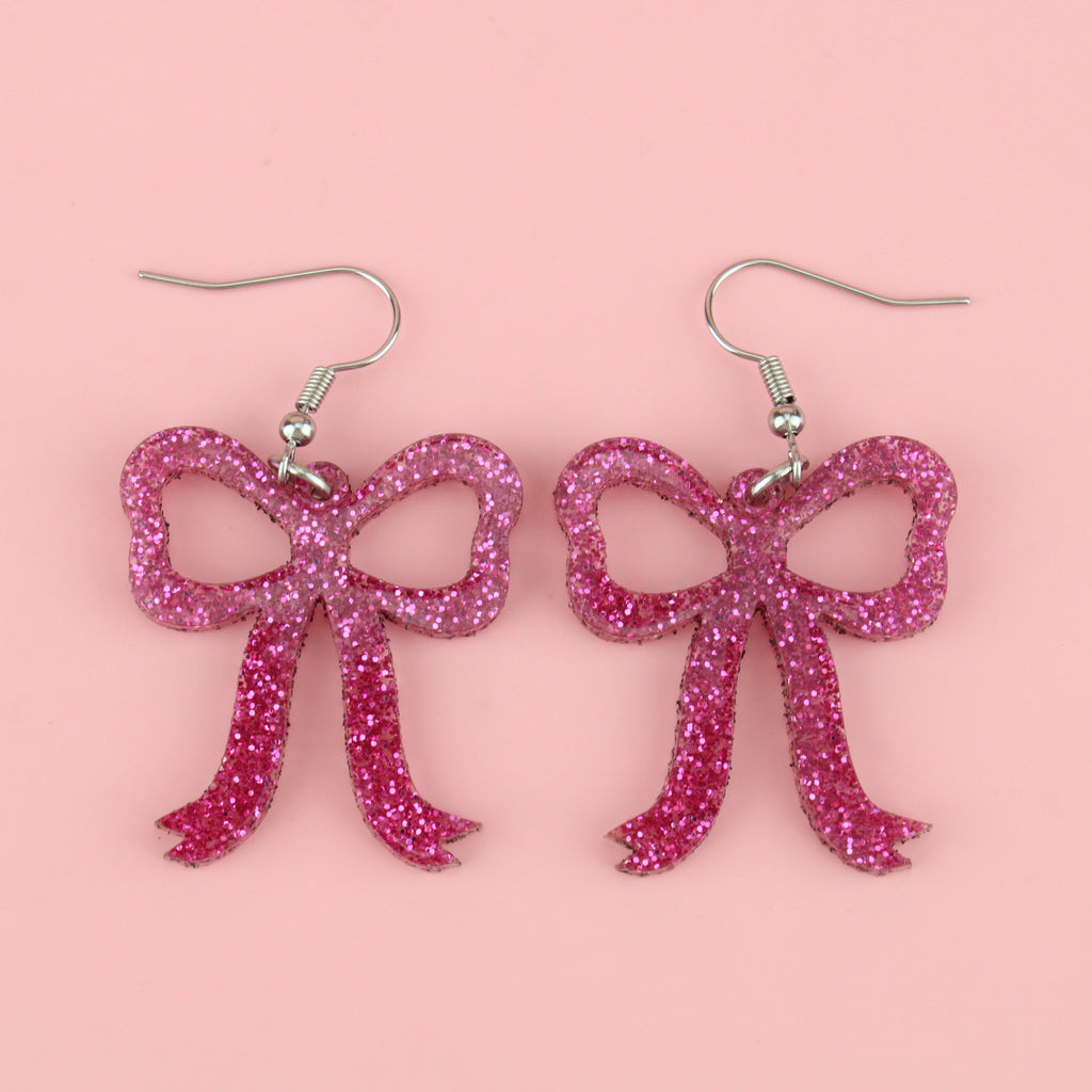Pink glitter bow charms on stainless steel earwires