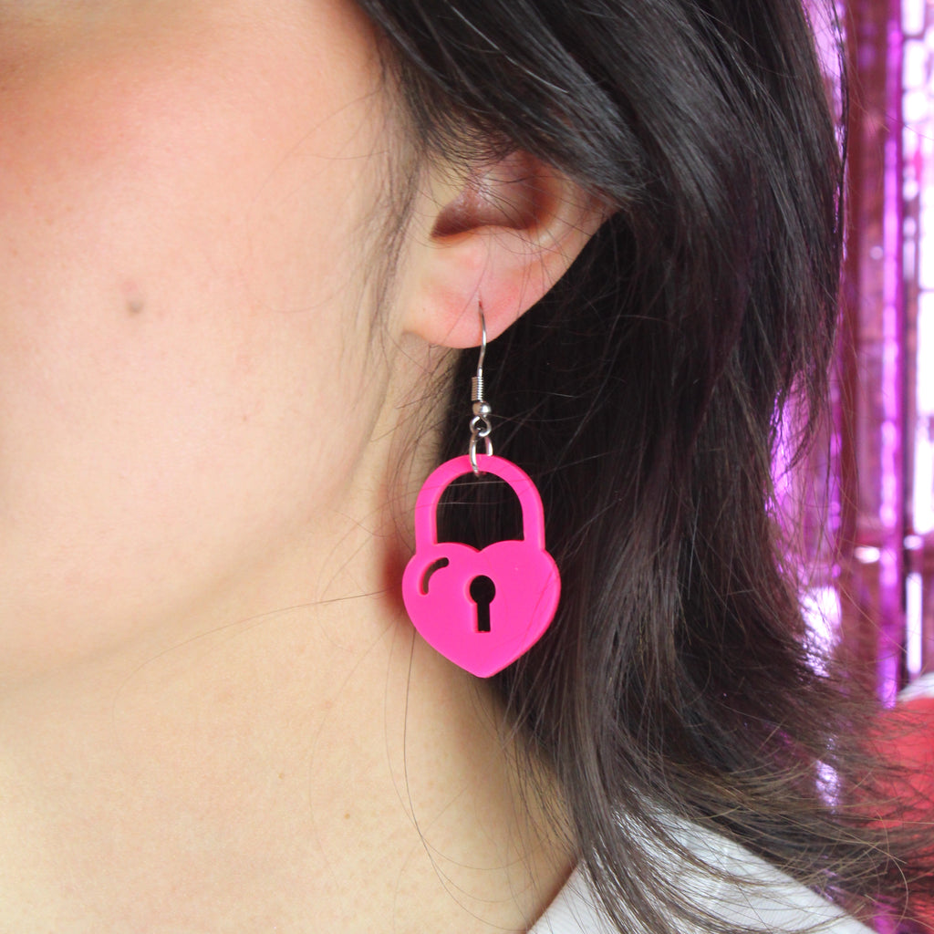 Model wearing pink heart padlock earring 