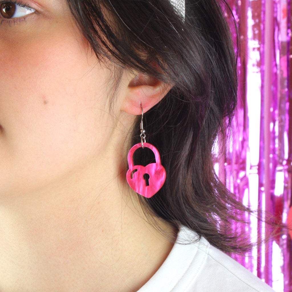 Model wearing Pink marble heart padlock on a stainless steel earwire