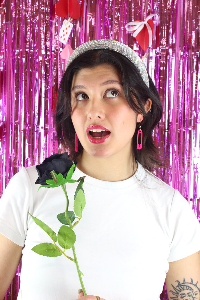 Model wearing Neon pink acrylic charms in the shape of a safety pin on stainless steel earwires