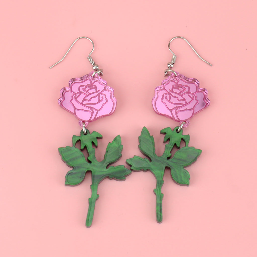 pink mirror acrylic roses and charming green acrylic thorn charms joined together hanging from stainless steel earwires