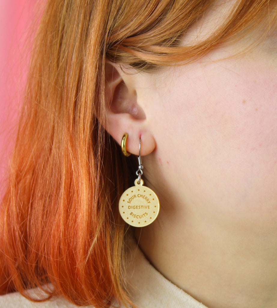 Digestive biscuit earrings worn by model