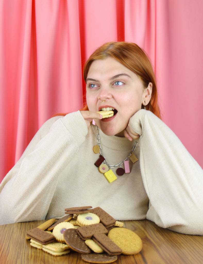 Woman eating cookies with a pink curtain background