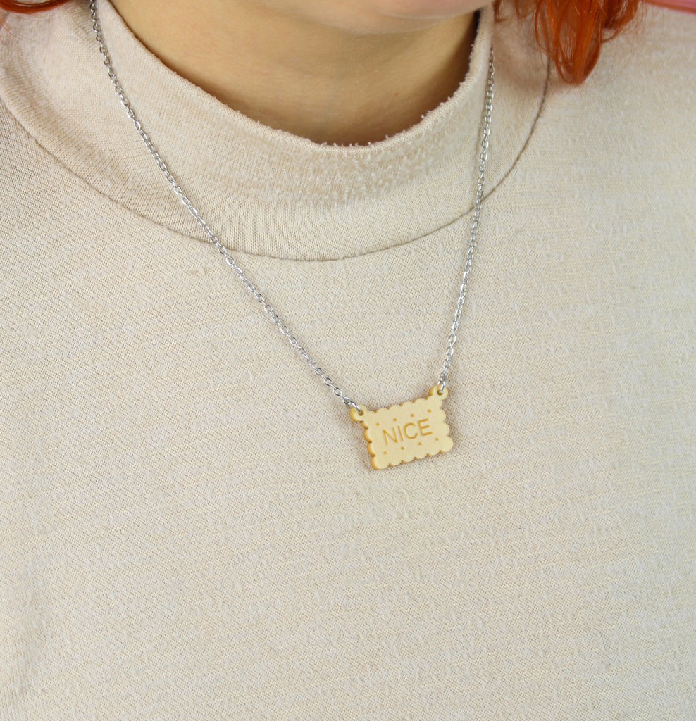 Necklace with a nice biscuit pendant worn by a person in a beige sweater.