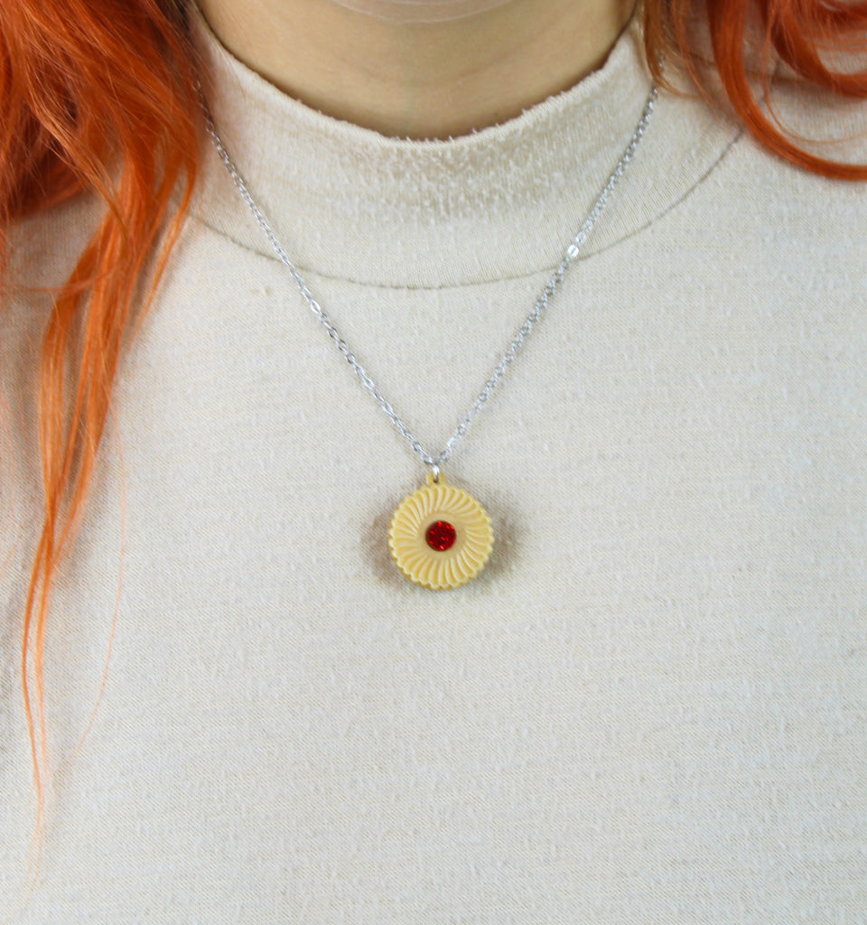 Necklace featuring a pendant of a jam and cream biscuit, worn by model