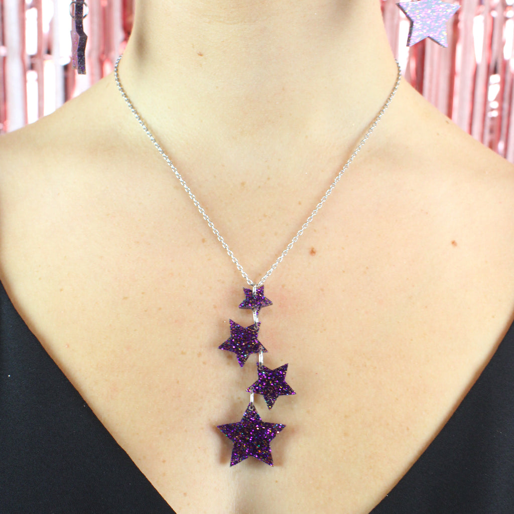 Model wearing Model wearing transparent star charms with purple glitter on a stainless steel chain