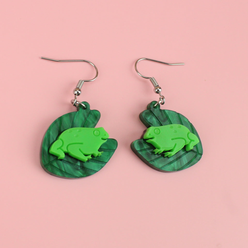 Dark green marble lily pads with green frogs in the middle on stainless steel earwires