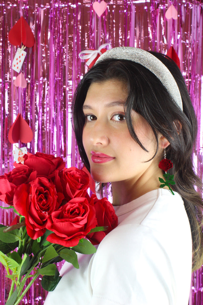 model wearing red mirror acrylic roses and charming green acrylic thorn charms joined together hanging from stainless steel earwires